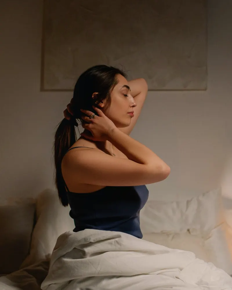Mulher cansada sentada na cama à noite